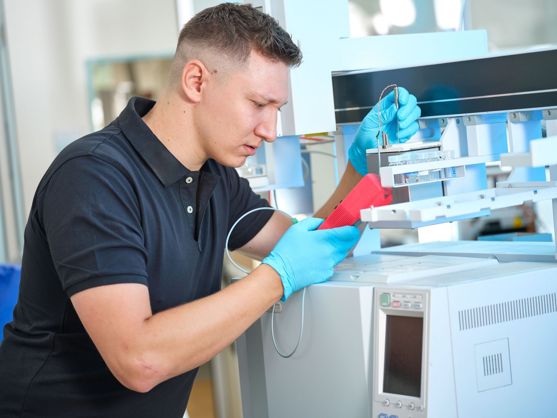 Gloved lab worker calibrating an analytical instrument used in automated processes like PAL Systems.”
