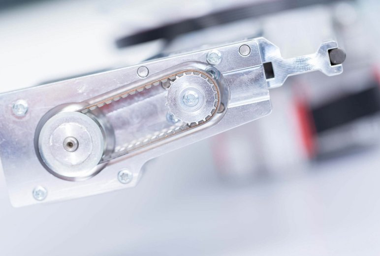 Close-up of a metallic mechanical component in a lab automation system, similar to parts used in PAL System